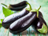 Des aubergines posées sur une table en bois